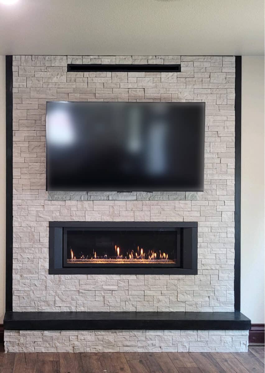 light colored stone fireplce with tv